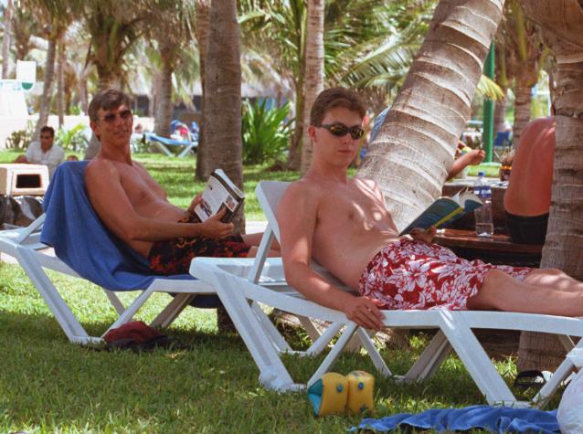 cancun4-24.jpg - Greg and Dad reading under the palm trees, NO it is not cold....