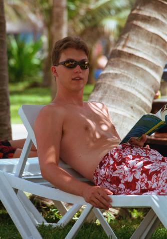 cancun4-26.jpg - Greg under the palm trees reading and relaxing